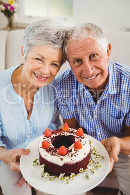 Senior couple holding a cake