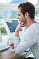 Handsome man working on computer and taking notes