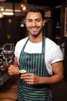 Smiling waiter drinking a coffee