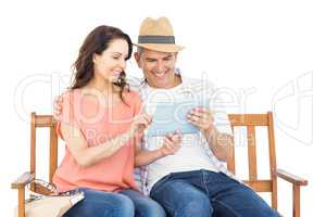 Couple on bench using tablet