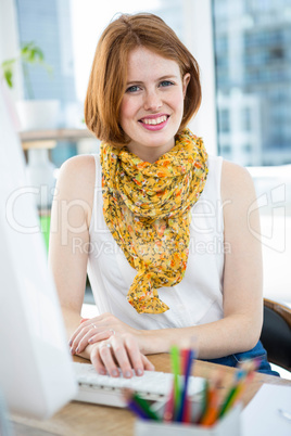smiling hipster woman sitting at a desk