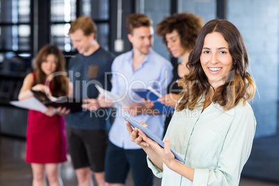 Portrait of smiling woman holding a digital tablet