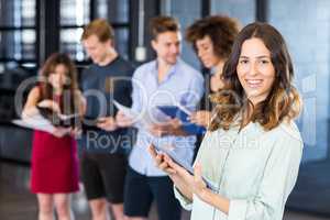 Portrait of smiling woman holding a digital tablet