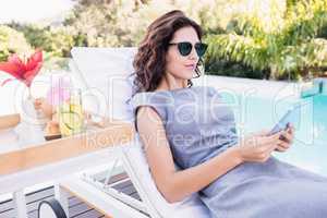 Young woman relaxing on a sun lounger near poolside