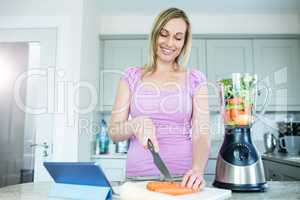 Blonde woman preparing the meal with tablet