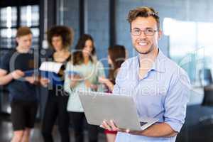 Portrait of man holding a laptop and smiling