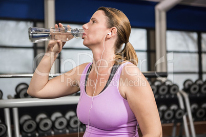 Woman drinking water and listening to music