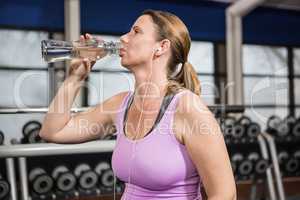 Woman drinking water and listening to music