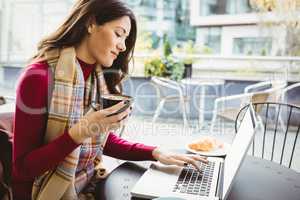 Woman using her laptop and drinking coffee