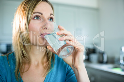 Pretty blonde woman drinking a glass of water