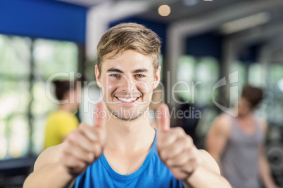 Muscular man posing with thumbs up