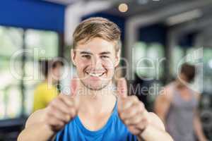 Muscular man posing with thumbs up