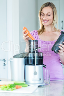 Blonde woman preparing a smoothie in the kitchen