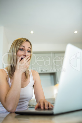 Pretty blonde woman looking at laptop