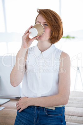 smiling hipster business woman drinking coffee in her office