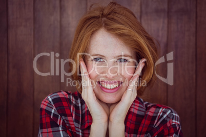 smiling hipster woman with her hands on her face