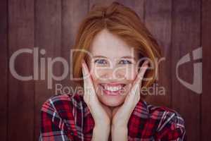 smiling hipster woman with her hands on her face