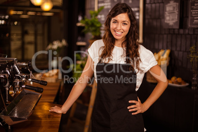 Pretty waitress posing next to coffee machine