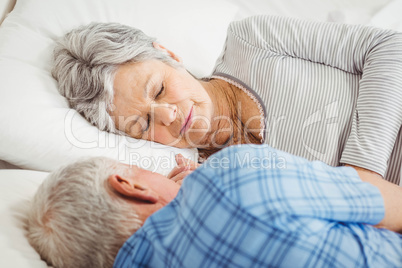 Senior couple sleeping on bed