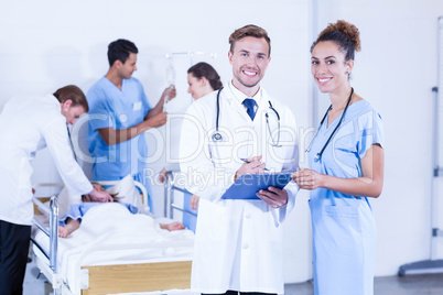 Doctors holding clipboard and smiling at camera