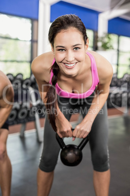 Pretty brunette lifting dumbbells