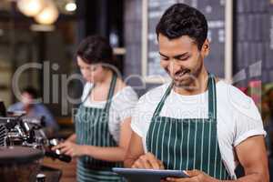 Smiling barista using tablet