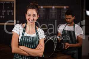 Smiling barista standing with arms crossed