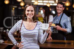 Smiling woman holding white cup