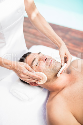 Man receiving a facial massage from masseur