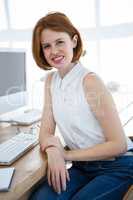 smiling hipsterbusiness woman sitting at a desk