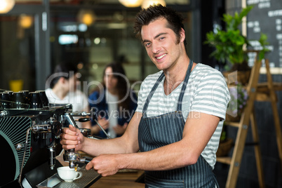 Smiling barista making coffee