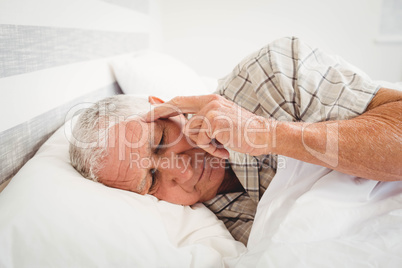 Frustrated senior man lying on bed