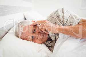 Frustrated senior man lying on bed