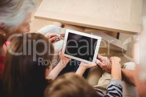Children using tablet with their grandparents