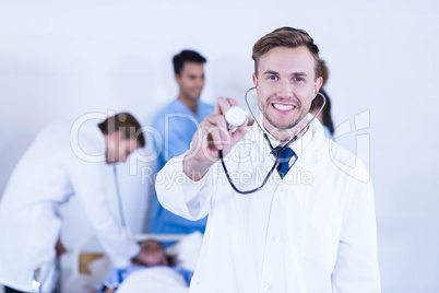 Doctor showing stethoscope towards camera