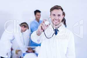 Doctor showing stethoscope towards camera