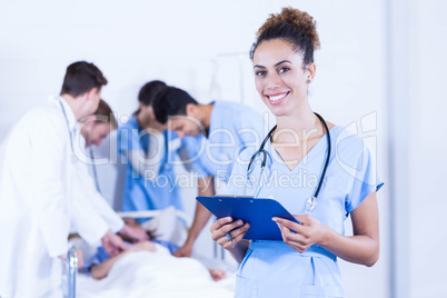 Female doctor holding clipboard and smiling at camera