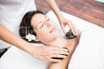 Woman receiving a hot stone massage from masseur