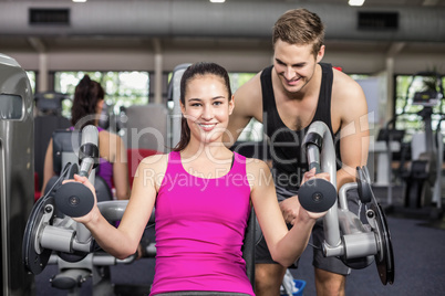 Trainer man helping athletic woman