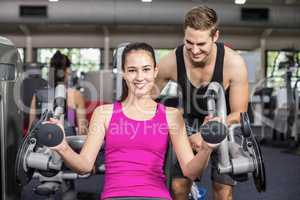 Trainer man helping athletic woman