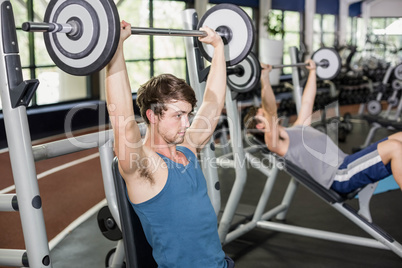 Fit man lifting barbell