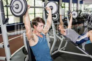 Fit man lifting barbell