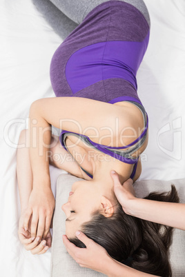 Trainer touching head of lying pregnant woman