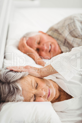 Senior woman covering her ears while man snoring