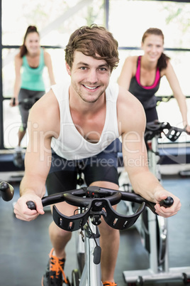 Fit group of people using exercise bike together