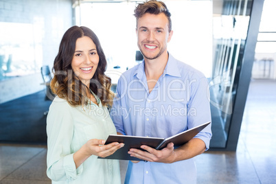 Businessman and businesswoman interacting holding organizer