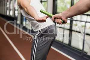 Man passing the baton to partner on track