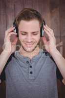 Handsome hipster listening to music with headphones