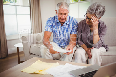 Senior man showing documents to woman