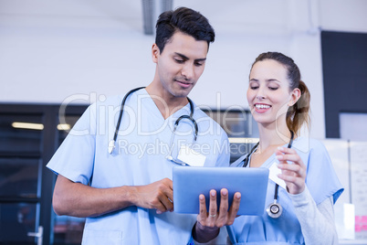 Doctors using digital tablet and smiling